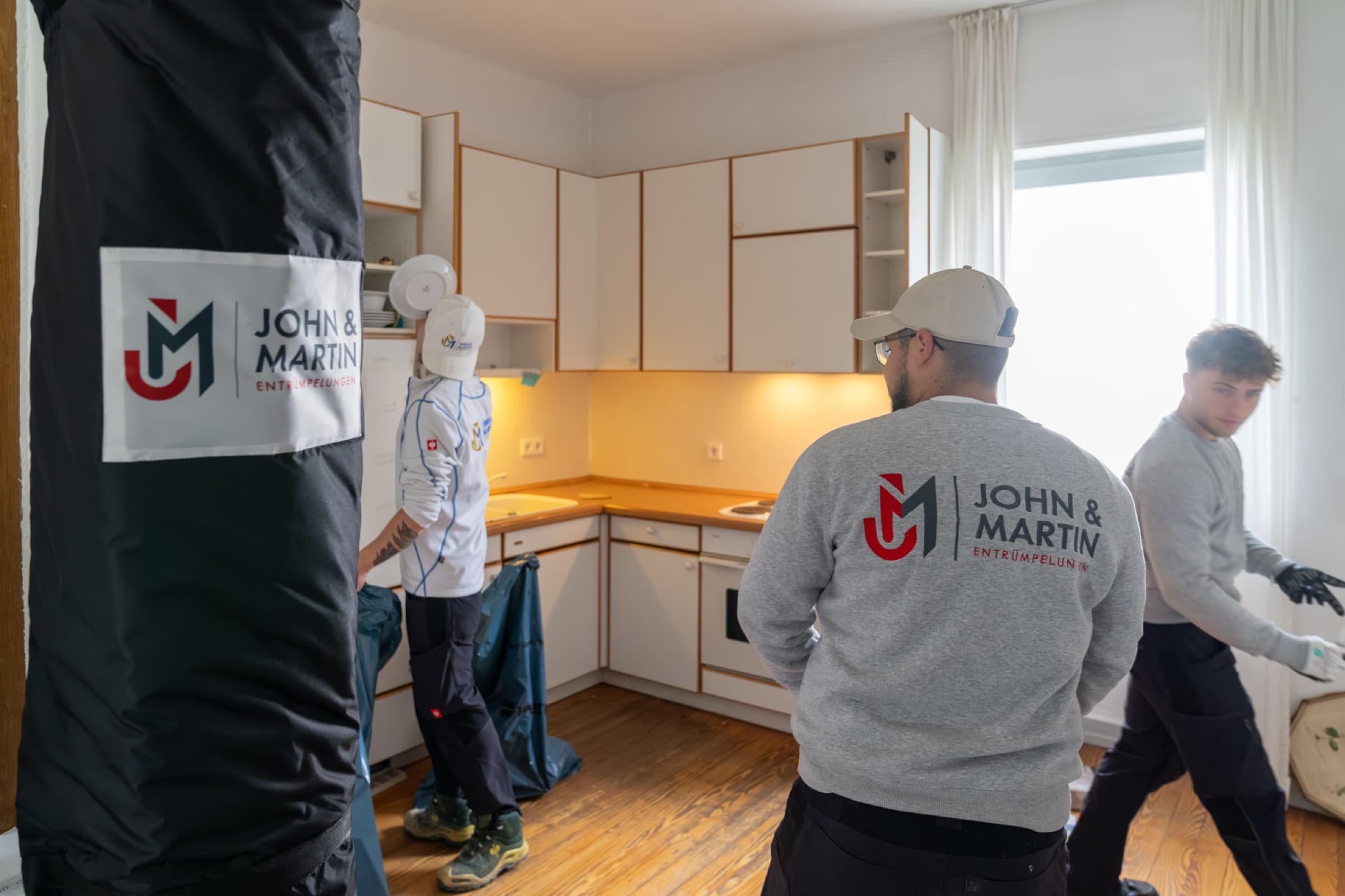 Team von John & Martin räumt eine Küche, Türrahmen ist mit Schutzhülle gesichert
